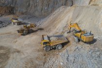 Loaders loading mining trucks at open pit — Stock Photo