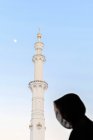 Silueta de mujer musulmana, cubierta de abaya negra en Gran mezquita - foto de stock
