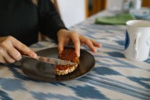 Девушка раздает кусок хлеба с веганским паштет — стоковое фото