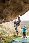 Sportlicher Mann klettert auf Felsbrocken und entdeckt Mann — Stockfoto