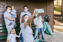 Группа волонтеров в медицинской маске делает селфи — стоковое фото