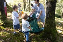 Volunteer children collecting garbage together with their families in — Stock Photo