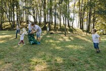 Группа волонтерских семей в парке помогает сохранить окружающую среду — стоковое фото
