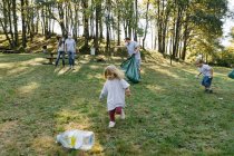 Group of volunteer families collecting garbage in a natural park — Stock Photo