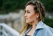 Close-up portrait of young woman with blonde colored braided hair looking to the side — Stock Photo