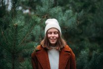 Pretty young woman in warm clothes standing and relaxing in park — Stock Photo