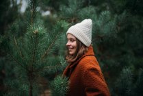 Pretty young woman in warm clothes standing and relaxing in park — Stock Photo