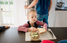 Young girl helping her dad make lunch at home before school — Stock Photo