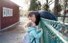 Pai beijando sua filha adeus no portão da escola — Fotografia de Stock