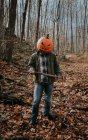 Man wearing scary carved pumpkin head in the woods for Halloween. — Stock Photo