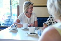 Lady having coffee with smiling friends — Stock Photo