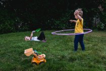 Um menino e uma menina brincam com brinquedos em seu gramado. — Fotografia de Stock