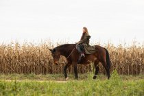 Jeune cavalière avec un cheval à l'extérieur — Photo de stock