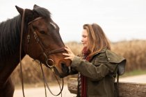 Молодая наездница с лошадью снаружи — стоковое фото