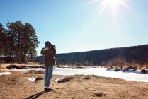 Chica joven con cámara explorando en las montañas rocosas - foto de stock