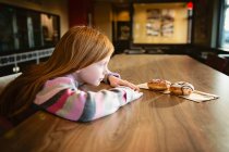 Маленькая девочка ест печенье на кухне — стоковое фото