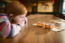 Маленькая девочка ест печенье на кухне — стоковое фото