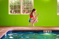 Jeune femme nageant dans la piscine — Photo de stock