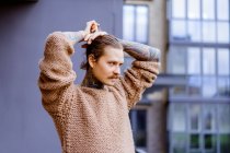 Guapo tatuado sexy hombre con el pelo largo y bigote al aire libre - foto de stock