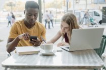 Pareja trabajando en la terraza de un bar en Barcelona - foto de stock