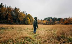 Homme debout au milieu d'un champ de campagne regardant et pensant — Photo de stock