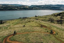 A group of girls bike along a trail overlooking the Columbia River. — Stock Photo