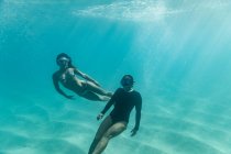 Deux femmes libres jouent sous la surface de l'océan — Photo de stock