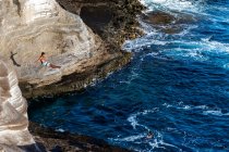 Male cliff diver dives towards the ocean in oahu, hawaii — Stock Photo
