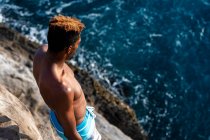 Masculino penhasco mergulhador olhando para a zona de salto do oceano antes de mergulhar em oahu — Fotografia de Stock