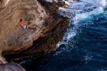 Plongeur de falaise mâle sportif saute dans l'océan à Oahu, Hawaï — Photo de stock