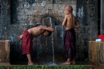 I monaci principianti si lavano sott'acqua all'esterno, vicino a Hsipaw, Myanmar — Foto stock