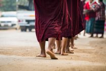 Monjes en la calle alineados y recibiendo limosna, Nyaung U, Bagan, Myanmar - foto de stock