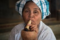 Бірманська жінка курить густу бірманську солом 