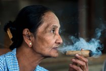 Birmano mujer fumando grueso Birmano paja cigarro, Bagan, Myanmar - foto de stock