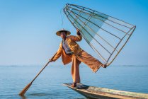 Pêcheur Intha posant avec un filet de pêche conique typique sur le bateau, Lac Inle, Nyaungshwe, Myanmar — Photo de stock