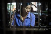 Asian woman working in weaving manufacture — Stock Photo