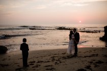 Recém-casados e filho de nove anos posando na praia ao pôr do sol em San Diego — Fotografia de Stock