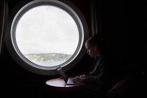 Un jeune cadre travaillant intensément sur son ordinateur portable sur un navire — Photo de stock