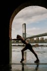 Silhouette einer Frau dehnt sich gegen Skyline — Stockfoto