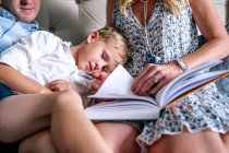 Close up of family snuggling and reading — Stock Photo