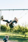 Little boy swinging high on a baby swing and having fun — Stock Photo