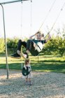 Menino balançando alto em um balanço do bebê e se divertindo — Fotografia de Stock