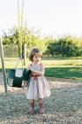 Little girl wanting to swing in the baby swing at a playground — Stock Photo