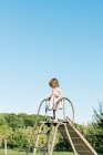 Little girl standing on top of a slide and feeling tall and brave — Stock Photo