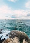 Эпический снимок человека в центре ландшафта, выходящего к морю — стоковое фото