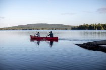 Couple paddle boating on beautiful pond — Fotografia de Stock
