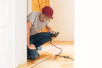 Homem adulto médio instalando piso de madeira em casa — Fotografia de Stock