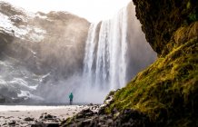 Uomo e bella cascata in montagna — Foto stock