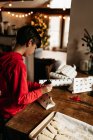 Хлопчик обгортає пісочне печиво, готове бути обдарованим на Різдво — стокове фото