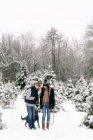 Giovane donna, giovane uomo e il loro cane alla fattoria dell'albero di Natale — Foto stock